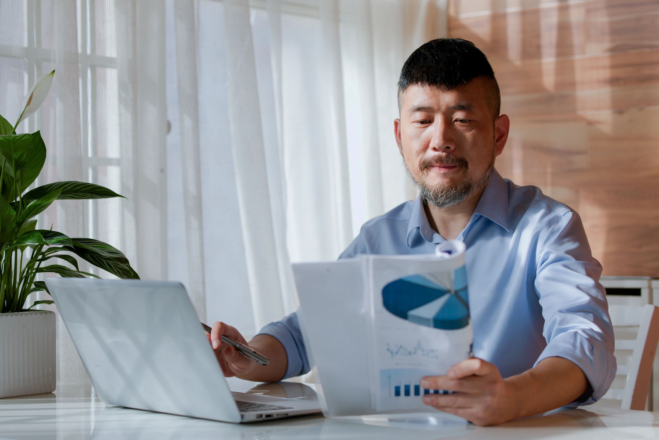 Consultant working on a laptop reviewing reports