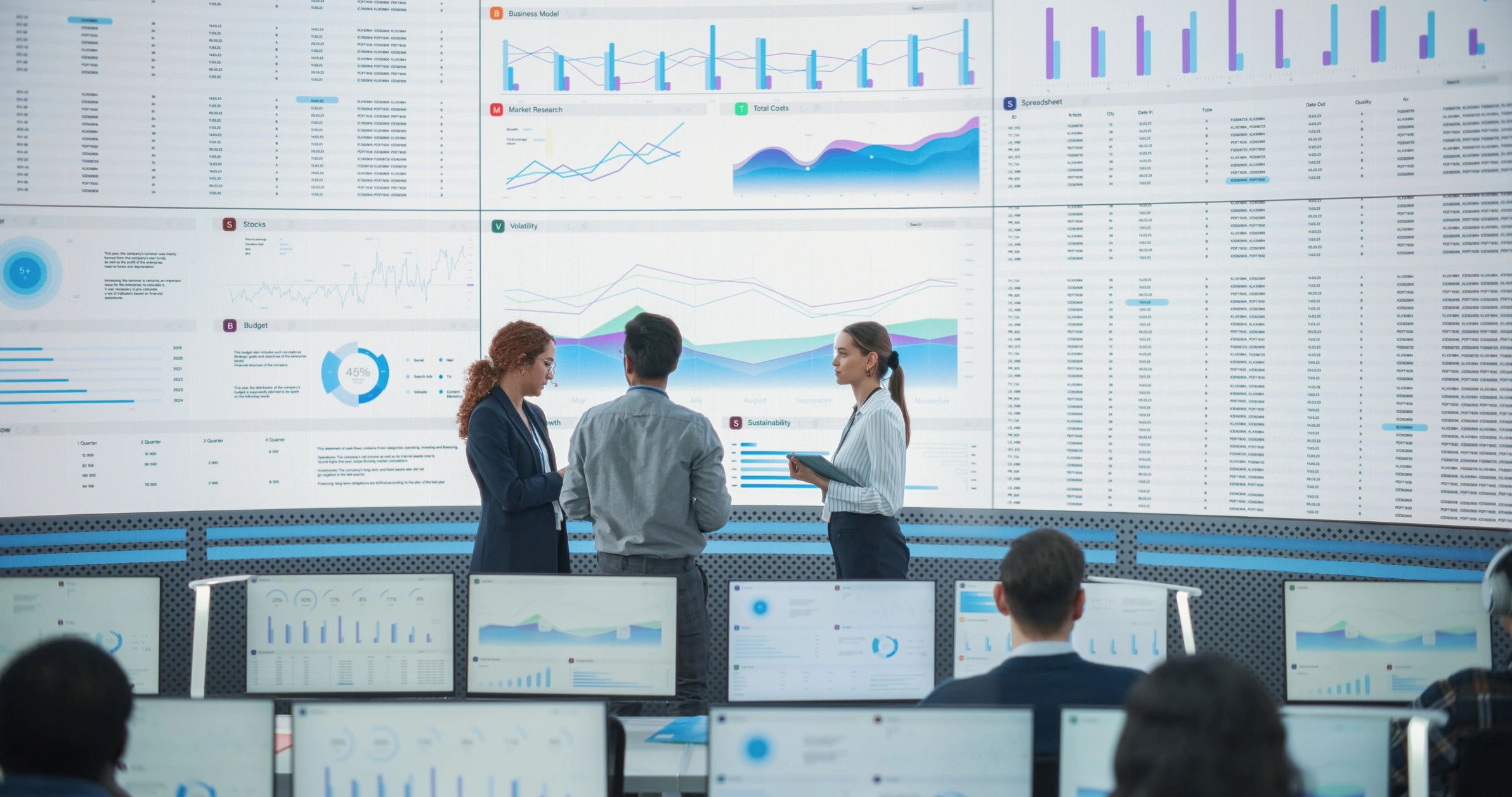 Data team discussing reports on a large digital screen