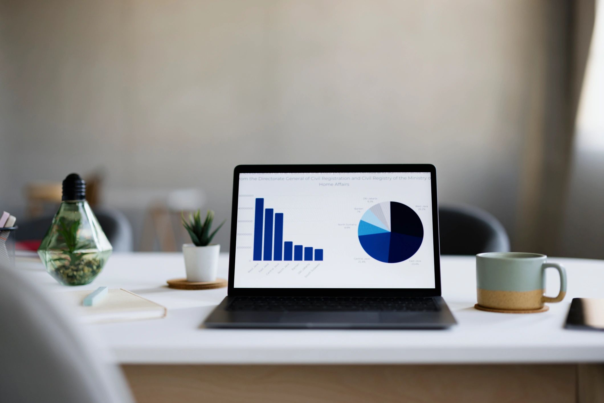 Laptop showing business charts and analytics in an office